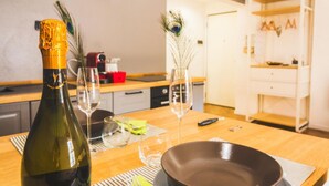 Une cuisine avec une table en bois, une bouteille de champagne et deux verres.
