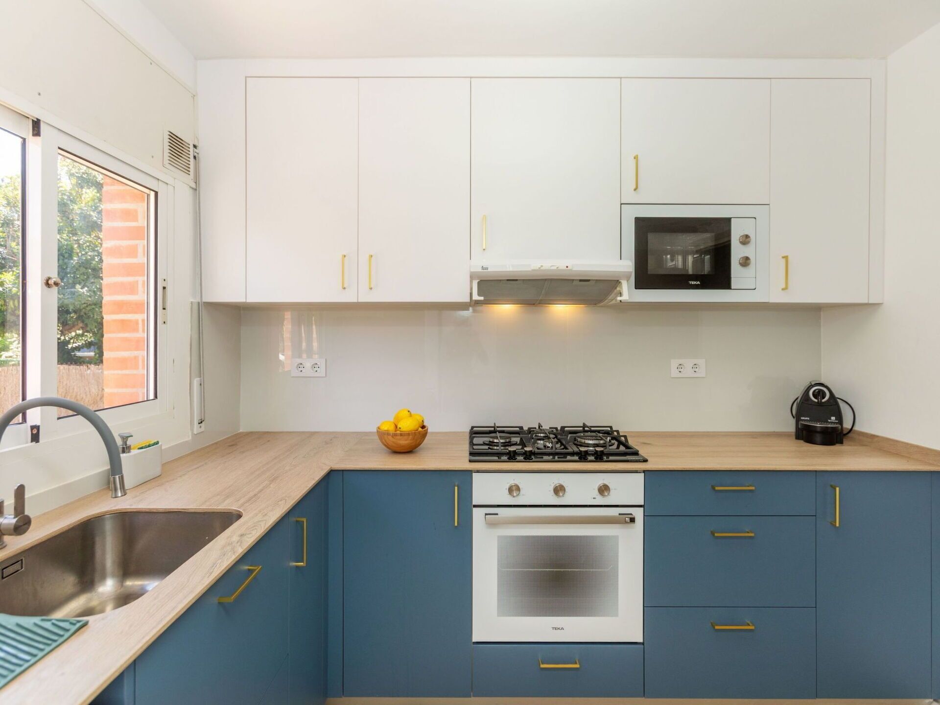 A modern kitchen with white cabinets, a gas stove, an oven, and a microwave.