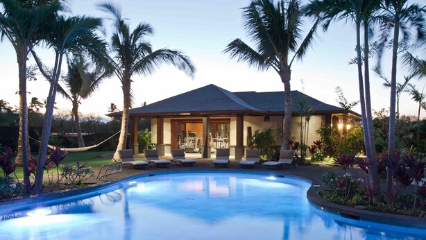 A swimming pool with lounge chairs and a covered area with exercise equipment. - Spectacular luxury golf course view home in the heart of the Mauna Lani resort (Kamuela)