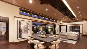A spacious living area with a large dining table, comfortable seating, and a modern ceiling design. - Spectacular luxury golf course view home in the heart of the Mauna Lani resort (Kamuela)