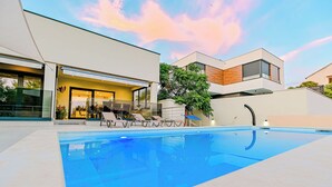 Una casa moderna con piscina, area relax all'aperto e giardino curato.