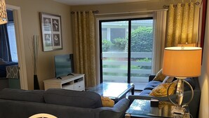 Uma sala compacta com sofá, mesa de jantar e televisão.