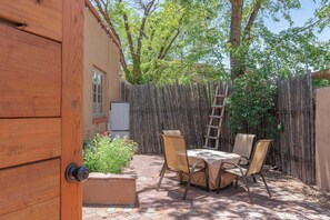 A wooden door, a table with chairs, a ladder, and a wooden fence. - Right on the Plaza next to O'keeffe Museum (Santa Fe)