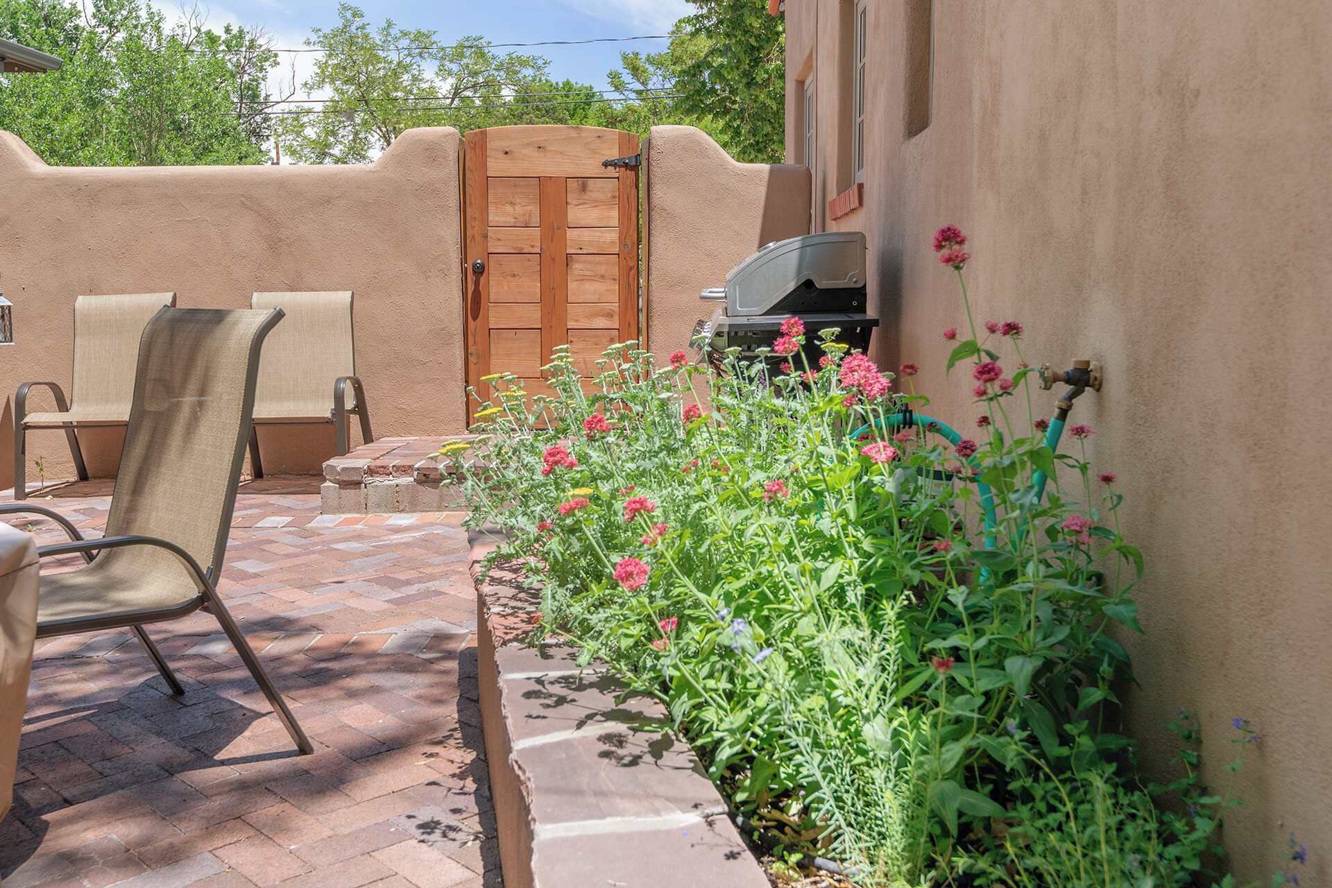 A patio with outdoor furniture, a wooden door, and a barbecue grill.