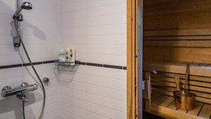 A bathroom with a shower, a wooden sauna, and a towel rack with toiletries. - Pike 2 as. 1 by Interhome (Nilsiä)
