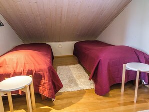 A small, cozy room with two beds, a white rug, and two small tables. - Pike 2 as. 1 by Interhome (Nilsiä)