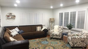 A living room with a brown sofa, patterned armchairs, a wooden floor, and a decorative rug. - Rustic Abode Entire Home- Near Logan (Hyde Park)