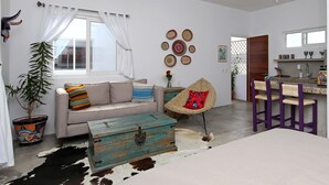 A living room with a sofa, a coffee table, a decorative chest, a chair, and a cowhide rug. - Peace amid the Palms at La Isla Bonita Villa 2 (Sayulita)
