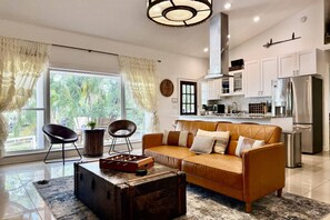 Una sala de estar moderna con un sofá, una mesa de centro y vistas al exterior.