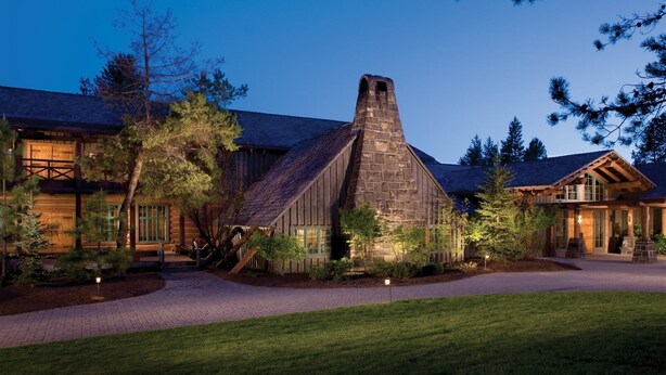 A rustic lodge with a prominent stone chimney, wooden exterior, and a well-maintained lawn. - Sunriver Family Escape with 6 SHARC Passes (Sunriver)