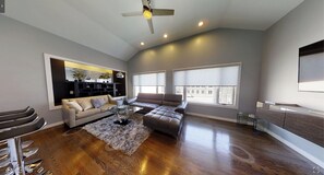 Relax in this stylish living room with a high ceiling, large window, and comfortable sofa.