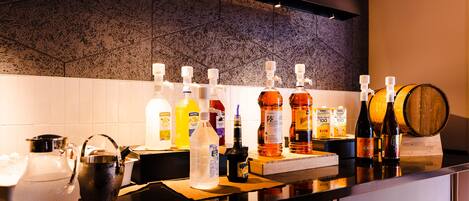 A bar area with various bottles and a large wooden barrel.