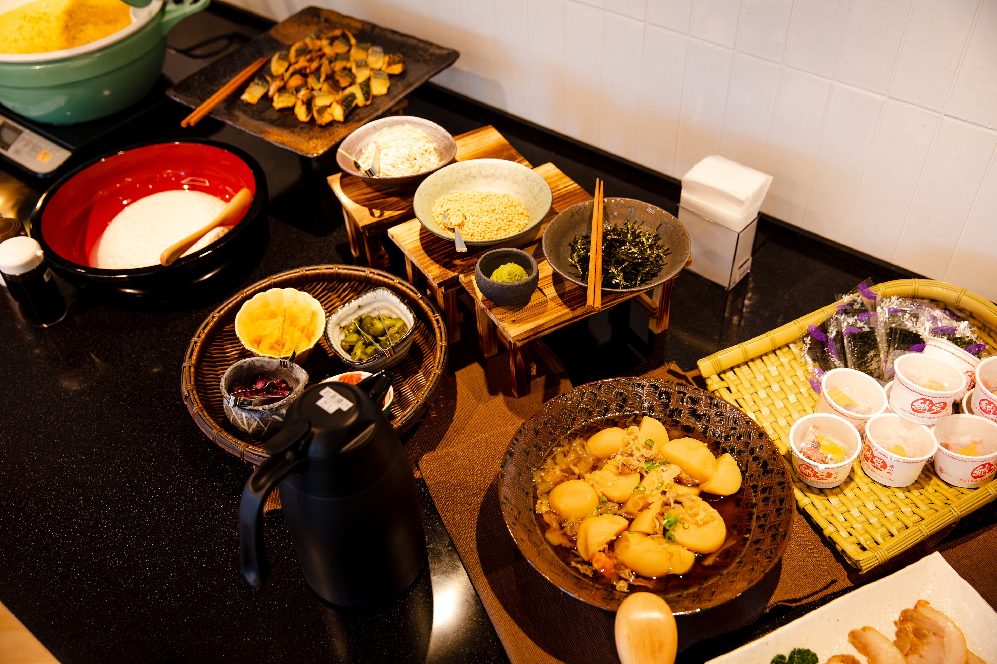 Variedad de platos y alimentos sobre una mesa, incluyendo tazones de arroz, verduras y otras especialidades de la cocina asiática.