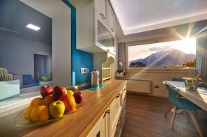 Eine moderne Küche mit Obstschale, Wasserkocher und Bergblick.