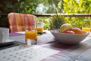A breakfast setting with a table, a bowl of fruit, and glasses of orange juice. - Villa Arrancada 7 with Mountain View, Pool, Garden & Wi-Fi (Vale de Margem)