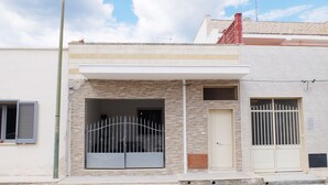 Ein zweistöckiges Gebäude mit flacher Fassade, einem verschlossenen Eingang und einem kleinen Fenster.