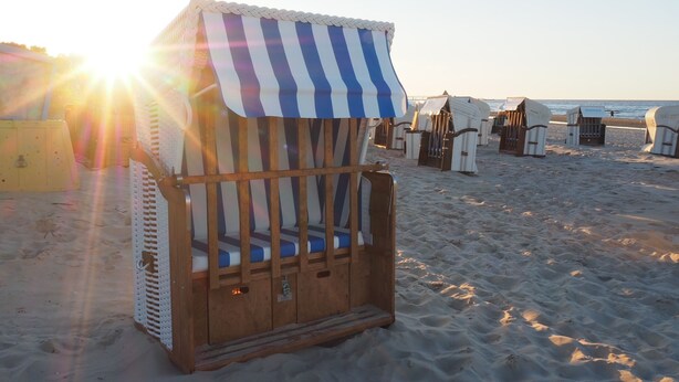 A beach chair with a striped awning, wooden frame, and cushioned seat. - Fewo Sonnenblick - Fewo Sonnenblick (Heringsdorf)