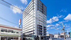 A multi-story building with a modern design, featuring a prominent vertical structure and a flat roof. - Gree (Otaru)