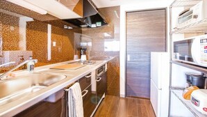 A modern kitchen with a granite countertop, stainless steel sink, and a built-in oven. - Gree (Otaru)