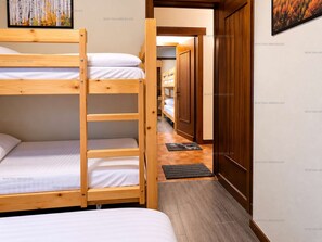 A room with bunk beds, a wooden door, and a hallway leading to another room. - Renovated studio with south-facing balcony, ideal for 4 people (Le Grand-Bornand)