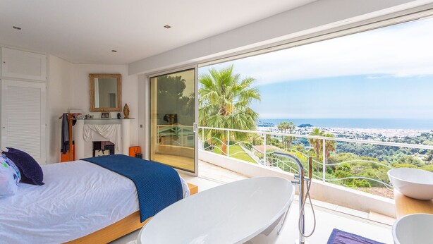 A bedroom with a large bed, a bathtub, and a balcony with a view of the sea. - VILLA NICE-GAIRAUT VI4230 BY RIVIERA HOLIDAY HOMES (Niza)