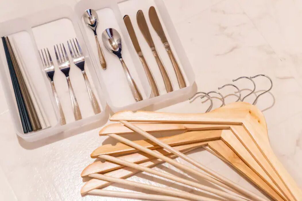 Un ensemble de couverts et d’ustensiles de cuisine en bois, présenté dans une boîte blanche.