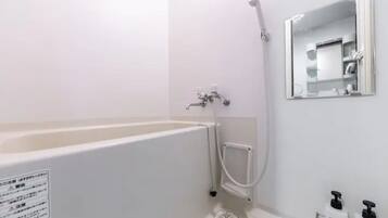 Un baño con bañera, ducha, lavamanos y espejo.