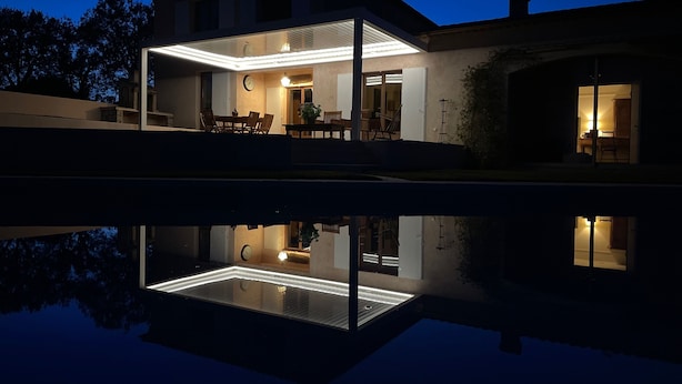 A modern house with a glass-enclosed patio, a dining area, and a visible kitchen. - An oasis of peace and quite with sea view on Cannes bay (Peymeinade)