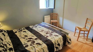 A bedroom with a bed, a chair, a desk, a window, and a hanging light fixture. - 3-Bedroom Apartment with Parking and Ski Locker, Cauterets (Cauterets)