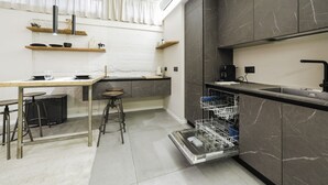 Una cocina moderna con armarios de mármol, lavavajillas integrado y un comedor con taburetes.