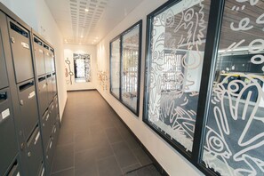 A hallway with filing cabinets, a bulletin board, and decorative glass panels.