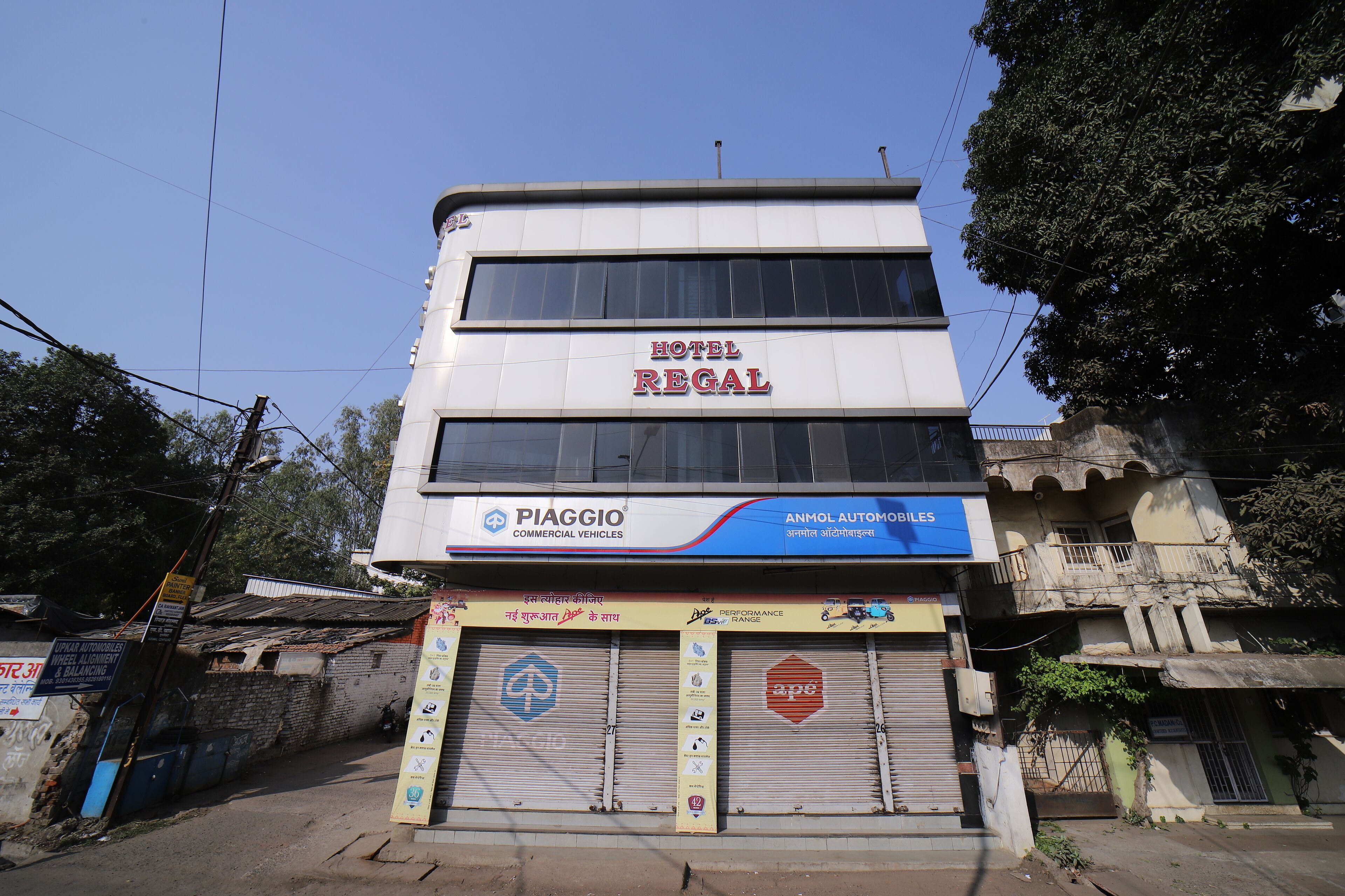 A multi-story building with a sign for 'Hotel Regal' and 'Piaggio Commercial Vehicles' on the ground floor.