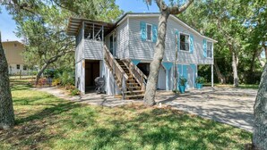 A two-story house with a covered porch, a staircase, and a barbecue grill in the yard. - Hawthorne - Fisherman's Delight! Plenty of Parking (Cedar Key)