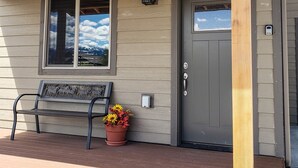 A wooden house with a bench, a door, and a mailbox. - Modern condominium in Ennis (Ennis)