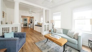 Un salon spacieux avec un canapé bleu, une table basse en bois et un canapé bleu clair agrémenté de coussins à motifs.