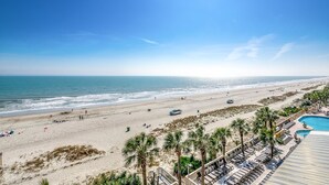 A beach resort with a swimming pool, palm trees, and beach chairs. - 🌟Large Oceanfront~Lazy River~Awesome Amenities~ Caribbean Resort 503🌟 (Myrtle Beach)