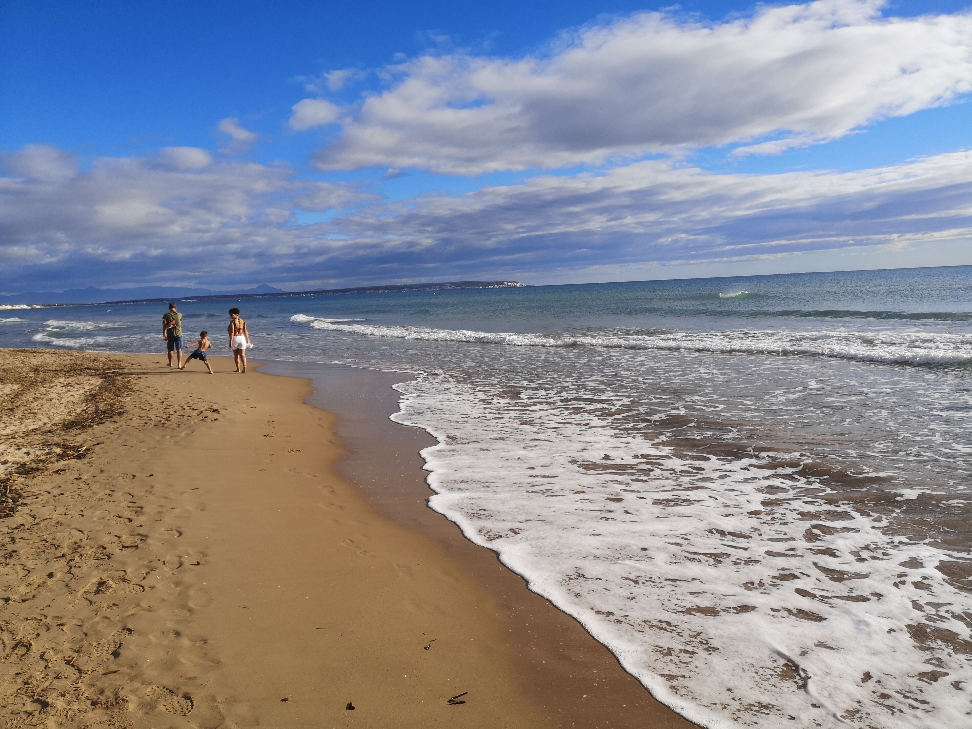Una spiaggia con una battigia sabbiosa e onde dolci.