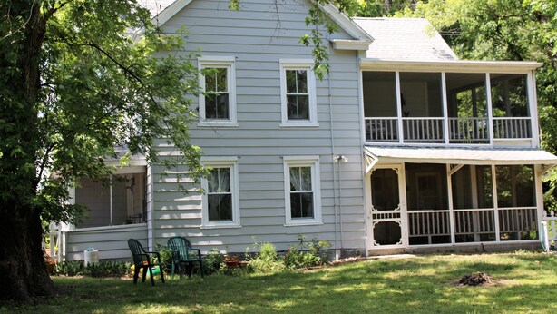 A two-story house with a porch and a covered front porch area. - Pine Island Retreat - 3BR's, 1st & 2nd level porches NO LINENS PROVIDED (Chincoteague)