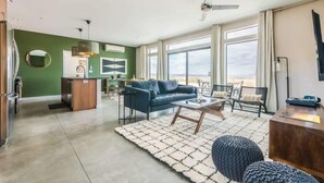 A spacious living area with a sofa, coffee table, and a view of the outdoors. - Estrella Perdida by Homestead Modern (Joshua Tree)