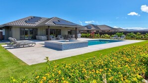 A modern house with a swimming pool, outdoor seating, and solar panels. - Luxury Home w/Pool + Spa | Sleeps 10 | Waikoloa Resort (Waikoloa)