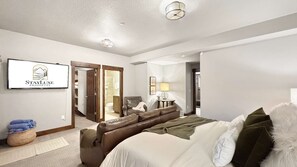 Een hotelkamer met een bed, een zithoek, een badkamer en een gang.