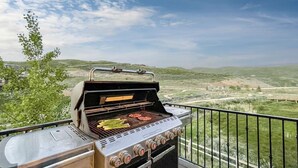 A barbecue grill with multiple burners and a view of a hilly landscape in the background. - Fall Mountain Retreat•Hot Tub•BBQ•Community Amenities•Uinta Foothill Views (Heber City)