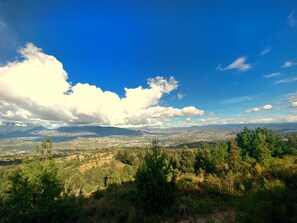 Ein weiter Panoramablick auf eine gebirgige Landschaft mit blauem Himmel und vereinzelten Wolken.