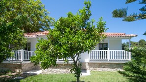 Ein zweigeschossiges Haus mit weißer Fassade, rotem Ziegeldach und einem weißen Balkon.
