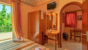 A hotel room with a bed, a wooden desk, a mirror, and a bathroom visible through an archway. - Villa Sophia by CorfuEscapes (Corfu)