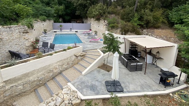 A rooftop pool area with lounge chairs, a table, and a covered seating area. - Old mill in the Luberon (Mérindol)