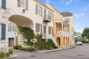 A row of townhouses with balconies, a paved street, and a clear sky. - Enjoy Park Circle's Best | Charming Little Mixson (North Charleston)