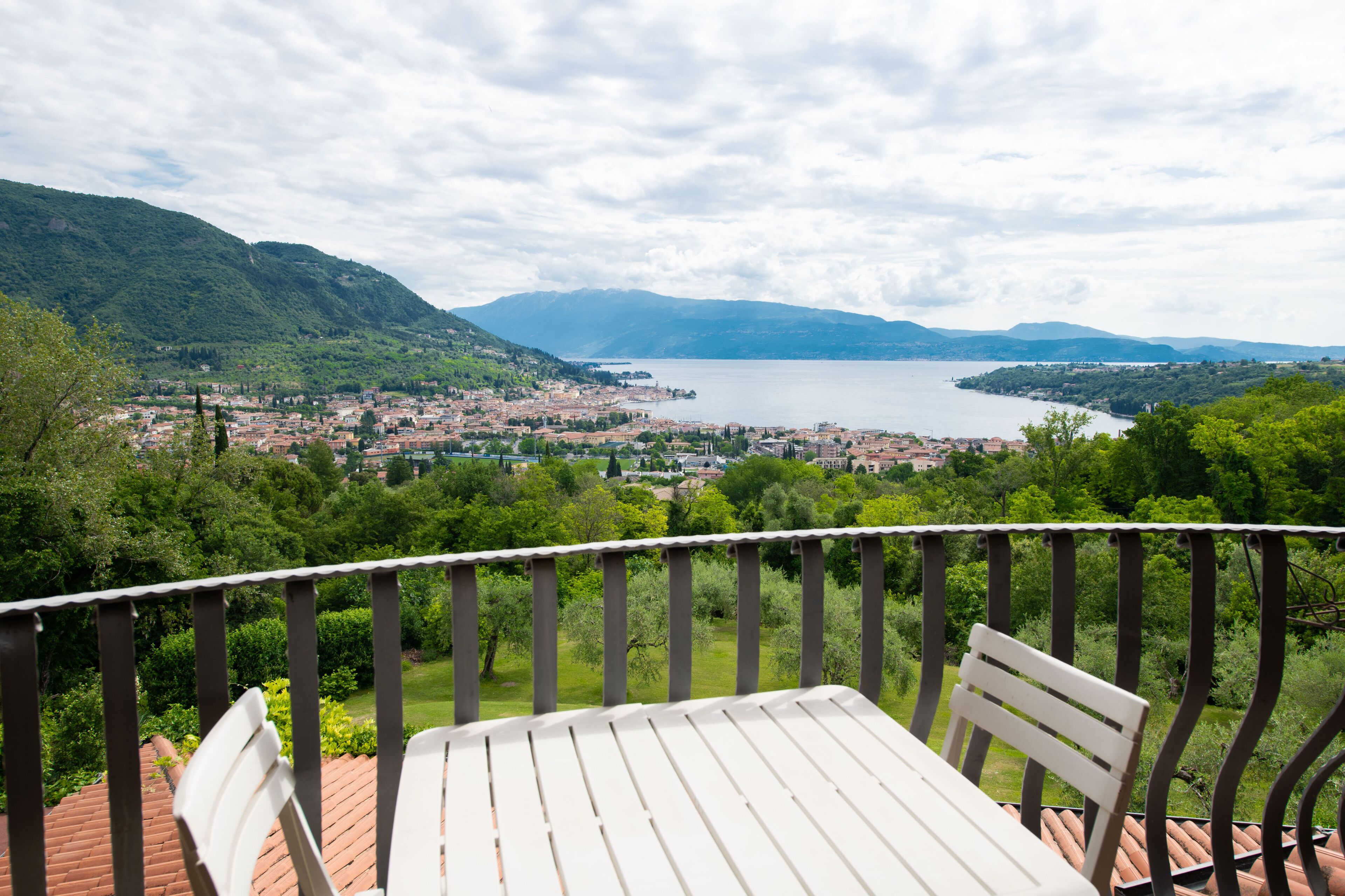 Une terrasse avec une table et des chaises donnant sur un lac et la ville.