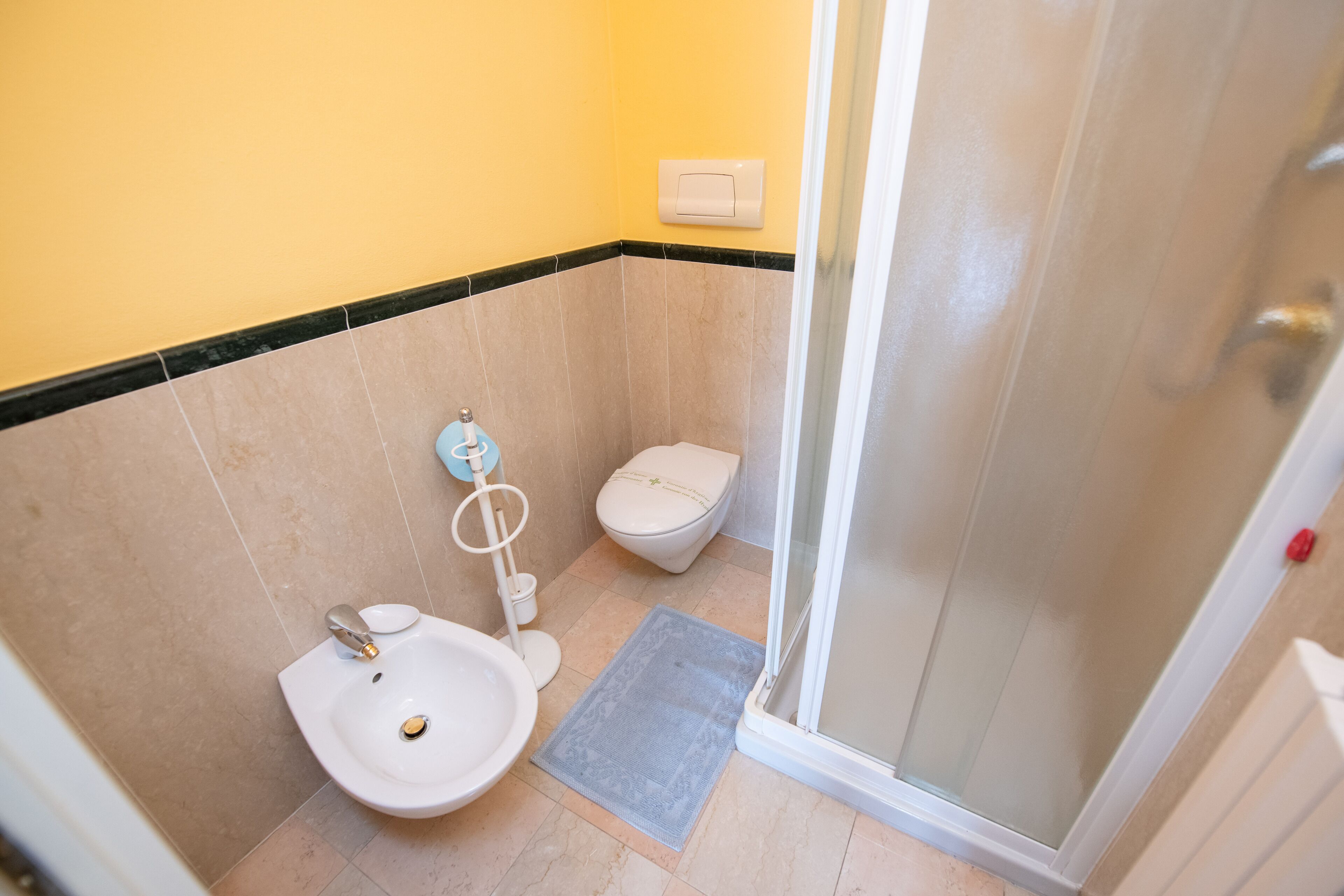 A small bathroom with a toilet, bidet, and sink.