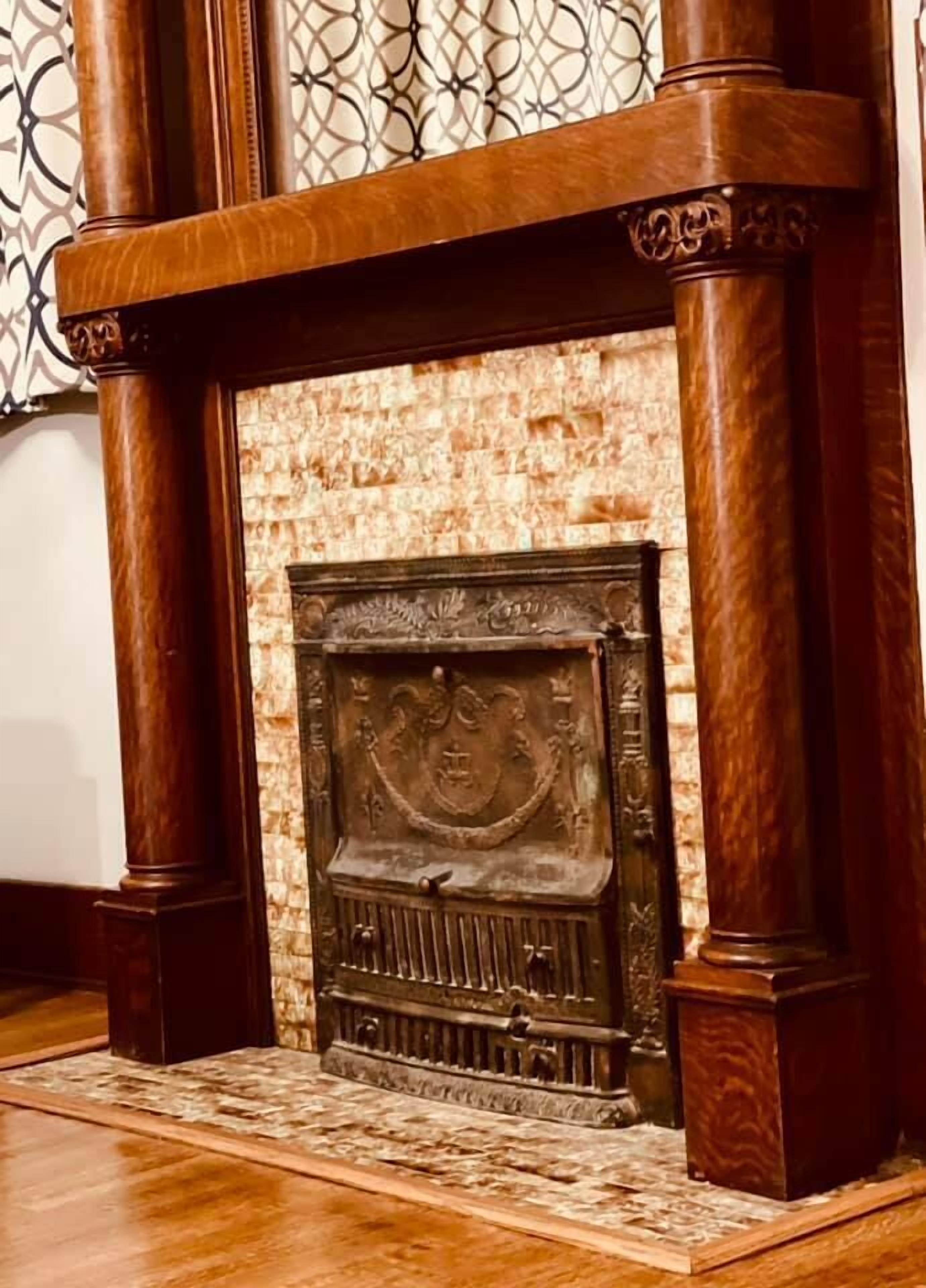 A fireplace with intricate carvings and a stone surround.